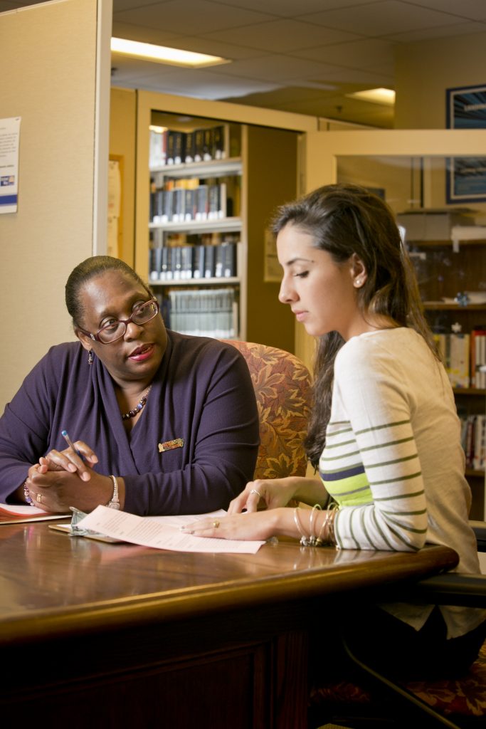 Iris Turrentine, a human resources associate in Perkins Library assists freshman Karla Beltran with her work/study paperwork